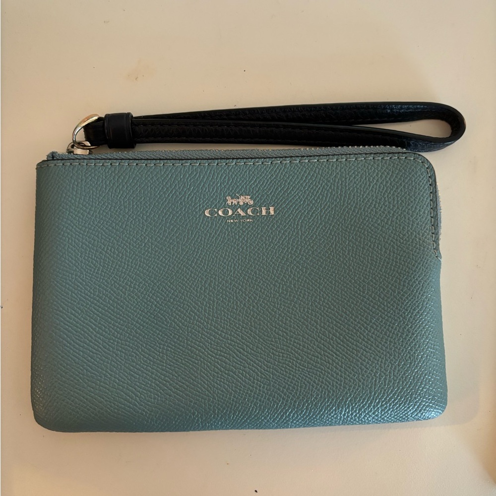 Light blue coach wristlet with dark blue strap.